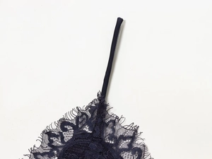 Close-up of delicate eyelash lace trim and thin straps on dark blue lingerie top