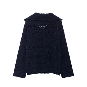 Detailed knit texture and openwork lace pattern on the collar of a dark blue cardigan