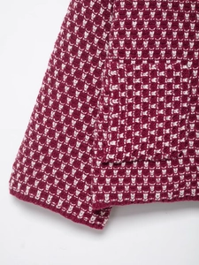 Detail of burgundy tweed knit cardigan featuring a textured geometric pattern and pocket