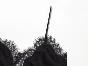 Detailed view of elegant black satin camisole featuring delicate eyelash lace trim at neckline