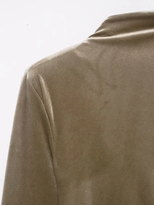 Close-up of shoulder stitching and luxe velvet texture on a champagne gold dress