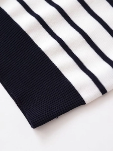 Detail of navy blue and white striped knit fabric with ribbed cuff texture on the sleeve