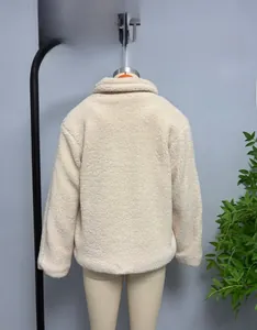Detail view showing the back tailoring and soft faux shearling texture of the cream jacket