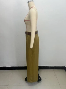 Detail view of mustard green wide leg trousers with premium satin texture and brown belt