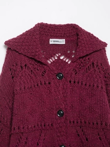 Detailed close-up of dark red chunky knit cardigan featuring oversized collar and hollow texture