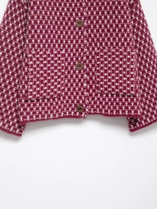 Detail of red and white plaid knit cardigan with textured brown buttons and premium weave