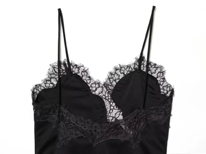 Detailed view of the delicate floral eyelash lace trim on a black silk camisole top