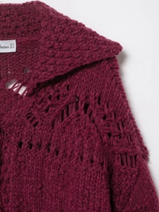Close-up of chunky knit hollow texture and collar detail on a burgundy cardigan
