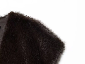 Macro detail of the plush faux fur texture and black fabric lining on the cropped vest