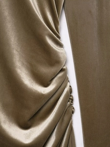 Macro shot of gold velvet fabric detailing gathered pleats and a silky texture finish