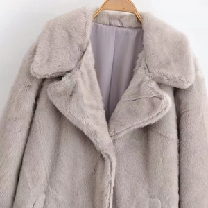 Detail of faux fur coat with oversized lapel and thick violet plush texture on hanger