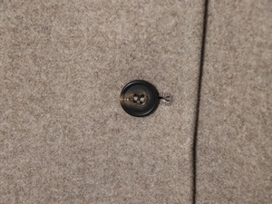Gros plan d'un bouton marbré sur un tissu en laine beige texturé de qualité supérieure