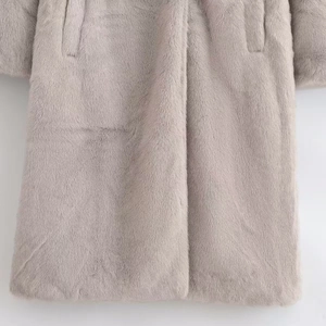 Close-up of thick faux mink fur texture on a light grey long-sleeved winter coat