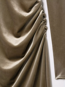 Detail of olive green velvet fabric showing elegant side ruched pleats and silky texture