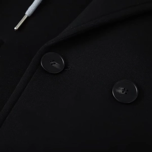 Detailed macro view of black hooded jacket featuring round buttons and grey drawstring tips