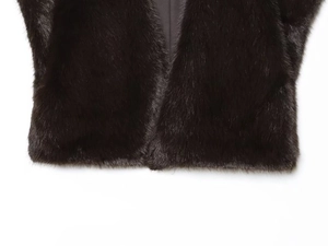 Close-up detail of smooth black faux fur texture and satin lining on a sleeveless vest