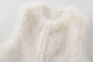 Macro view of white faux fur texture and round neckline of a soft fluffy vest