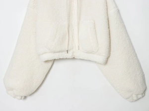 Detail of soft white faux fur sherpa zip-up hoodie with drawstring and side pockets