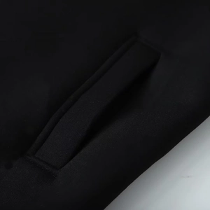 Macro shot of stitching detail and fabric texture on a black hooded long coat pocket