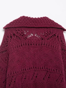 Macro shot of dark burgundy chunky knit cardigan featuring hollow geometric patterns