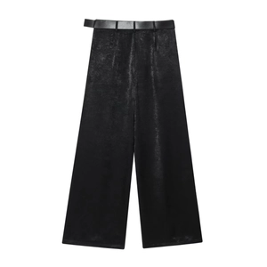 Detail view of high-waisted black wide-leg trousers with matching belt and silky luster