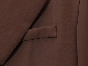 Close-up of deep brown twill blazer featuring refined stitching and premium pocket detail