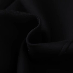 Detail of smooth black polyester fabric texture with soft drapes and subtle glossy finish