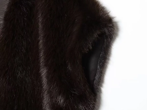Detail of faux fur vest showing plush dark texture and smooth black inner lining