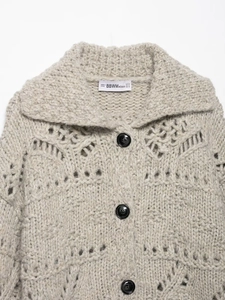 Detail of chunky knit cardigan featuring lapel collar and openwork hollow texture