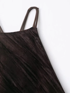 Detailed macro view of deep coffee velvet fabric and thin straps on the evening dress