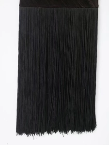 Close-up of black fringe detail with matte velvet texture on a stylish bandage dress