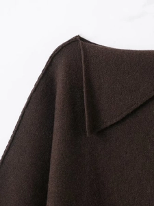 Close-up of the dark brown knitted collar and shoulder stitching on a fashion sweater