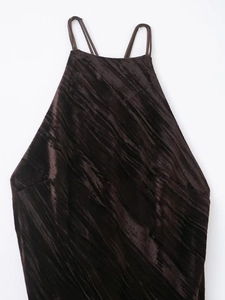 Detail of dark brown crushed velvet fabric on a halter-neck dress with fine pleat textures