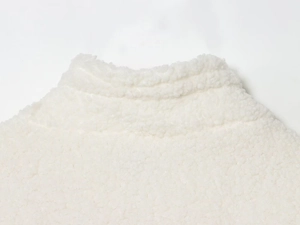 Close-up of white fleece texture and high collar detail on a casual women jacket