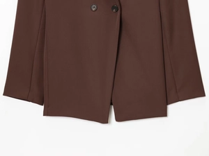 Detailed close-up of dark brown blazer with textured fabric and double-breasted buttons