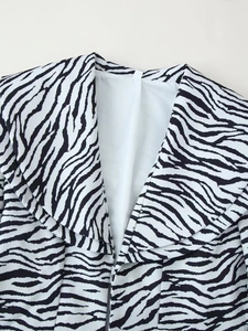 Détail de la texture du tissu blazer à imprimé zèbre noir et blanc et du col à revers