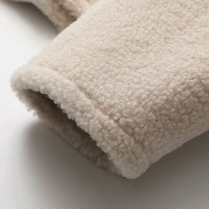Vue macro de la texture moelleuse en peau de mouton sur les poignets de la veste