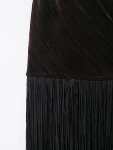 Detail of black embossed velvet dress showing layered high-density fringe hem design
