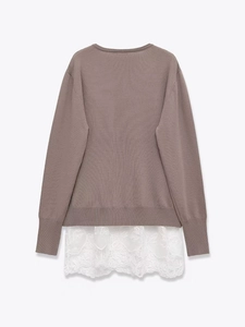 Détail du pull en maille grise à col en V avec dentelle florale blanche élégante à l'ourlet
