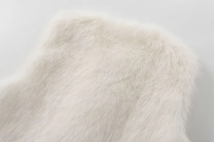 Detailed close-up showing the soft texture and fluffy white faux fur fabric of the vest