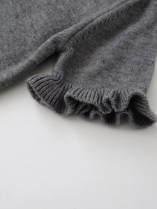 Dettaglio ravvicinato di tessuto a maglia grigio con orlo a balze elegante