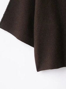 Close-up of deep brown knit fabric showing soft texture and premium fine stitching details