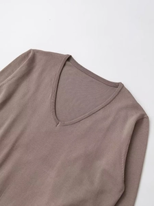 Détail du col en V avec texture en maille côtelée sur un pull élégant couleur taupe