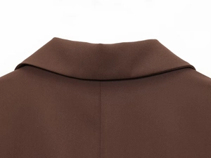 Detailed macro view of deep brown blazer lapel showing fine twill fabric texture