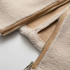 Détail du tissu sherpa crème et de la fermeture éclair métallique marron de haute qualité