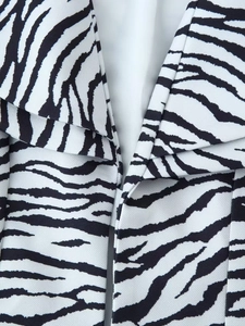 Détail de la veste à motif zèbre montrant le tissu sergé et la doublure blanche