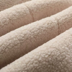 Gros plan du tissu polaire effet mouton blanc cassé doux pour veste confortable