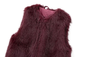 Detail of burgundy faux fur vest showing plush texture and smooth satin lining