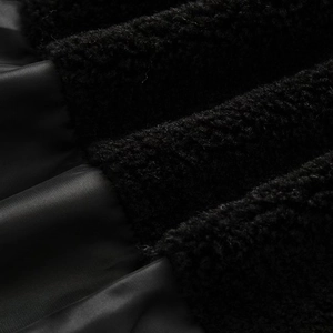 Detailed close-up of the black waterproof fabric and warm shearling lining texture