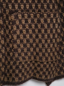 Macro shot of vintage diamond pattern textured chunky knit cardigan in brown and beige